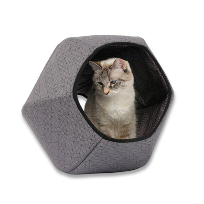 A tiny six-pound cat demonstrates our Cat Ball® cat bed made with cotton fabric that looks like a grey geometric web with a coordinating lining. Our hexagonal cat cave design has two openings and is flexible, lightweight, and made in the USA.