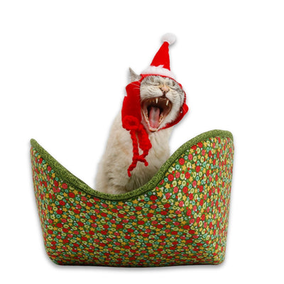 A tiny seven-pound cat demonstrates our jumbo-size Cat Canoe® cat bed, made with a Scandinavian Christmas ornament fabric. This bed is designed for big cats.